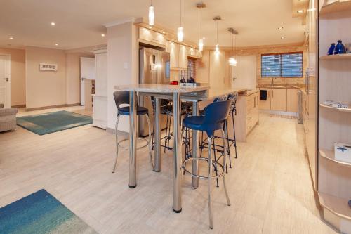 a kitchen with a island with bar stools at Hermanus Haven, entire home, on the sea, private pool, secure in Hermanus