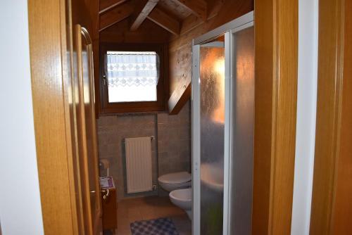 a small bathroom with a toilet and a window at Star Begn in Soraga