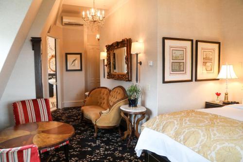 a hotel room with a bed and a table and chairs at The Chanler at Cliff Walk in Newport