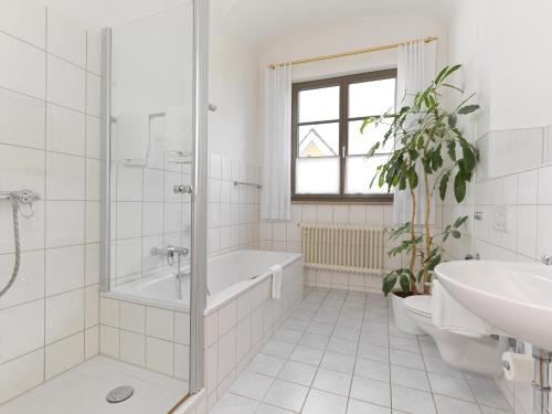 a white bathroom with a tub and a sink at Lodner Hotel Drei Mohren in Lauingen