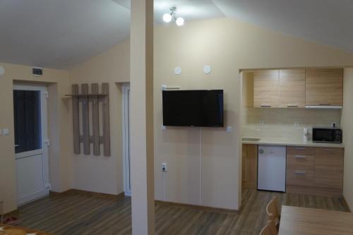 a room with a kitchen with a tv on the wall at Dessi in Pleven