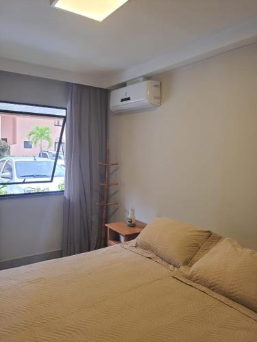 a bedroom with a bed and a window at Flat em Genipabu Summer House in Guarajuba