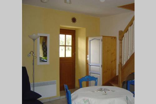 gelbes Zimmer mit einem Tisch und einer Treppe in der Unterkunft Ti Dour - Gîte de charme à la campagne - côte de granit rose in Bégard