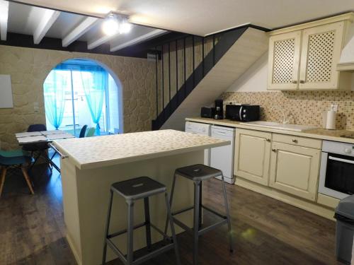 - une cuisine avec un comptoir et des tabourets dans l'établissement LA MAISON DU LAC climatisée et WiFi gd F3, à Port-la-Nouvelle