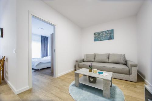 een woonkamer met een bank en een tafel bij Lovely Home at West Residence in Oradea