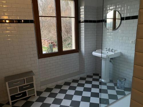 Baño blanco con lavabo y espejo en L’aile droite du château, en Lebétain