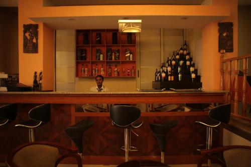a man sitting at a bar in a restaurant at C Fun Addis Hotel in Addis Ababa