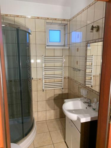 a bathroom with a glass shower and a sink at Villa Remedios in Łeba
