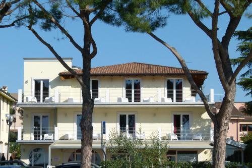 un grande edificio bianco con alberi di fronte di Boutique Hotel Bel Sito Wellness & Private SPA a Bardolino