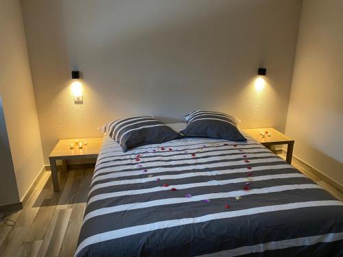 ein Schlafzimmer mit einem großen Bett mit zwei Nachttischen in der Unterkunft L’aile droite du château in Lebétain