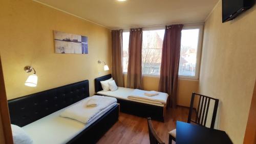 ein kleines Zimmer mit 2 Betten und einem Fenster in der Unterkunft Silver Park Vendégház in Berettyóújfalu