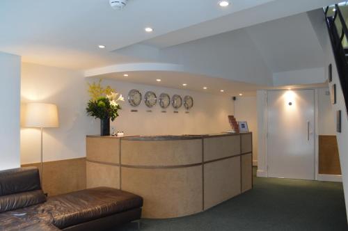 a lobby with a reception desk and a couch at Accommodation London Bridge in London