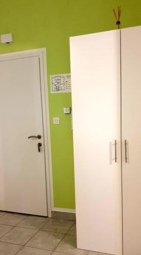 two white doors in a room with green walls at IstraNova Apartments in Rovinj