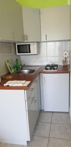 a small kitchen with white cabinets and a sink at IstraNova Apartments in Rovinj
