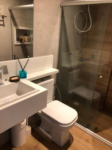 a bathroom with a toilet and a sink and a shower at Flat em Genipabu Summer House in Guarajuba