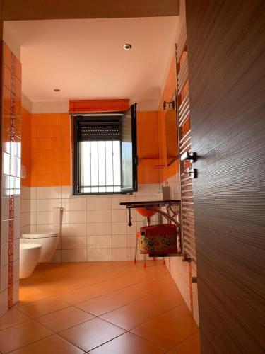 a bathroom with a toilet and a sink and a window at Villa Alfonso con vista mare in Siculiana Marina