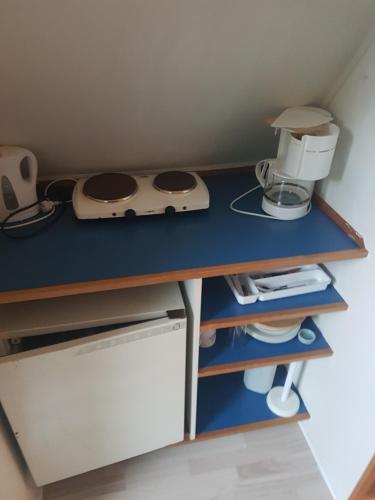 een kleine keuken met een blauw aanrecht met een apparaat erop bij Stege camping hytte 3 in Vordingborg