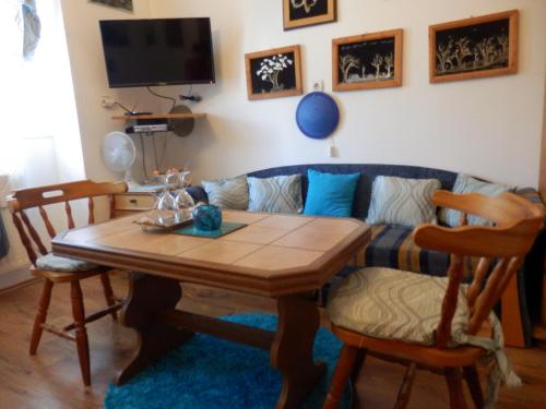 a living room with a table and a couch at Guesthouse Ilona in Veľký Kamenec