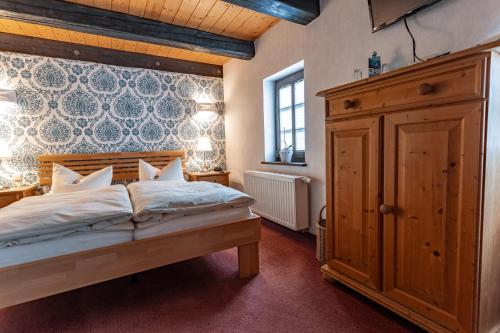 1 dormitorio con 1 cama grande y armario de madera en Weingut Schuh - Pension Zur Bosel, en Coswig