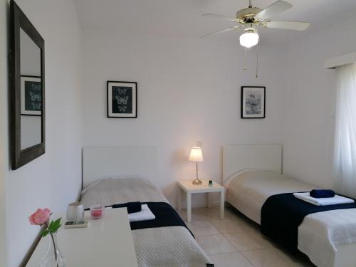 a bedroom with two beds and a ceiling fan at Paradise Gardens II Anastasia Apartment in Paphos