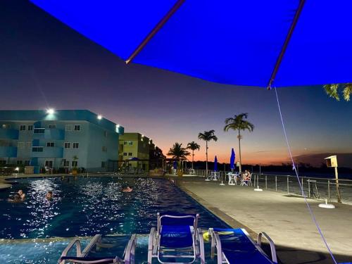 uma piscina com cadeiras na água à noite em Apto Arraial do Cabo - Condomínio Golden Lake em Arraial do Cabo