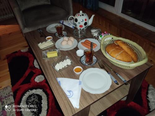 un tavolo con pane e un cesto di cibo sopra di Buta Hotel Lerik a Lerik