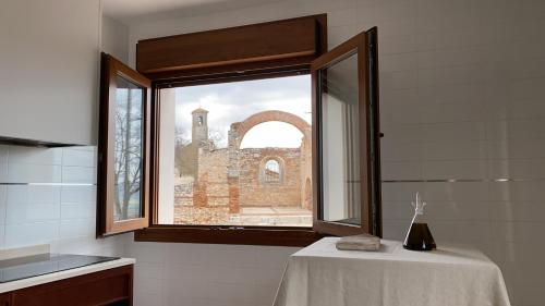 uma janela num quarto com uma mesa e um edifício em Casas de San Pedro em Hita