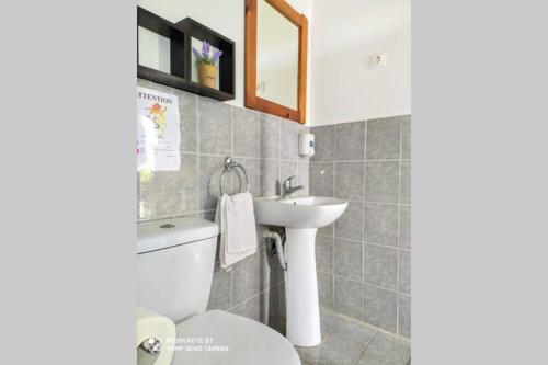 a bathroom with a toilet and a sink at Raisin House in Koukounariá