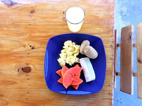 a blue plate with food and a glass of milk at Hotel Las Vegas by CMS hotels in Santa Marta