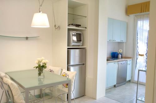a kitchen with a table and a kitchen with white cabinets at Hotel Eros Residence in Cervia