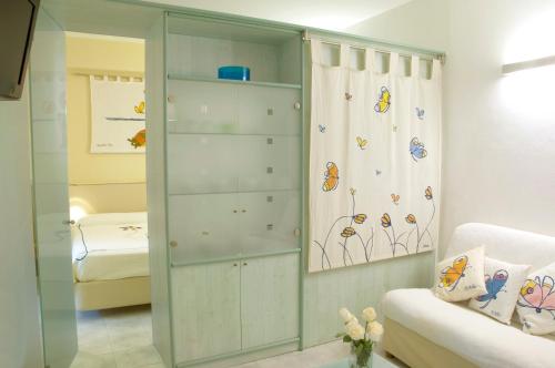 a living room with a glass cabinet with butterflies on it at Hotel Eros Residence in Cervia