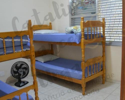deux lits superposés dans une chambre avec fenêtre dans l'établissement 03 Dormitorios em Frente a Praia do Itararé / S.V, à São Vicente