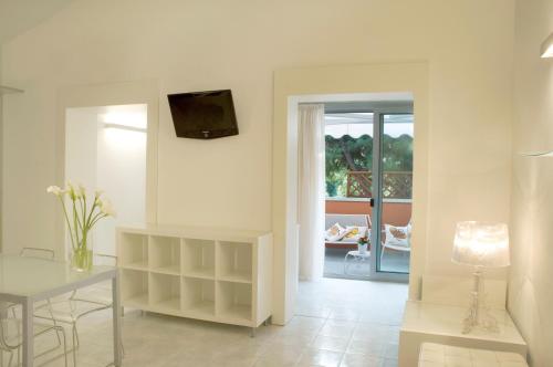a living room with a table and a tv on the wall at Hotel Eros Residence in Cervia