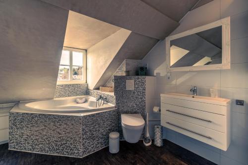 uma casa de banho com uma banheira, um lavatório e um WC. em Oriental Cozy Loft - Orientalisches gemütliches Loft em Weibern
