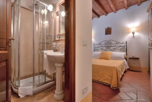 a bathroom with a bed and a shower and a sink at First of Florence in Florence