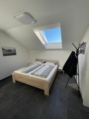 a bedroom with a bed and a skylight at Gästehaus Veenstra in Kelberg