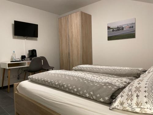 a bedroom with two beds and a desk with a computer at Gästehaus Veenstra in Kelberg