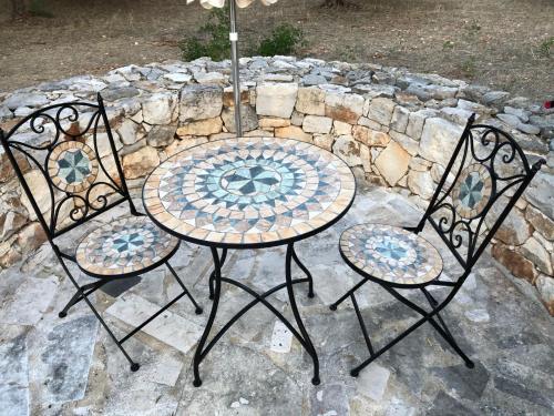 a table and two chairs with a table and an umbrella at Trullo Tita in Monopoli