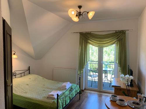 a bedroom with a bed and a table and a window at Villa Remedios in Łeba