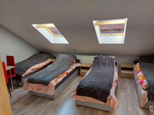a attic room with three beds and two skylights at VMax-Auto Kwatery/Hostel Pokoje Tranzytowe 