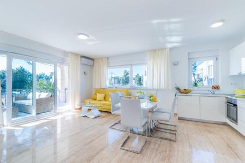 uma cozinha branca e sala de estar com um sofá amarelo em Apartment Maria Vir em Vir
