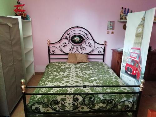a bedroom with a bed with a green bedspread at Specchia Terrazza&Tavernetta Arcobaleno in Specchia