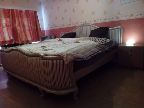 a large bed in a bedroom with a night stand at La clef de bois in Braine-le-Comte