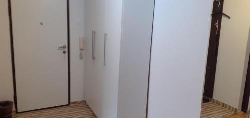 a white closet with three doors in a room at Apartman centar lux in Tuzla
