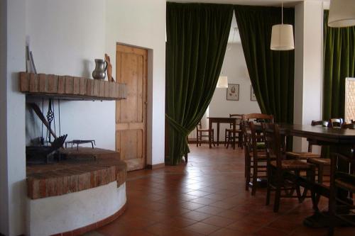 a living room with a fireplace and a dining room at La Locanda Cuccuini in Cavriglia