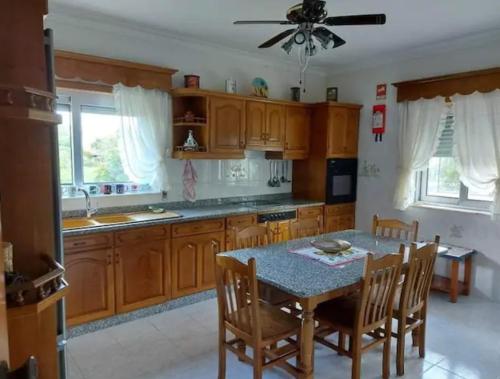 a kitchen with wooden cabinets and a table with chairs at Casa da Cavada - 6 quartos-rooms in Caminha