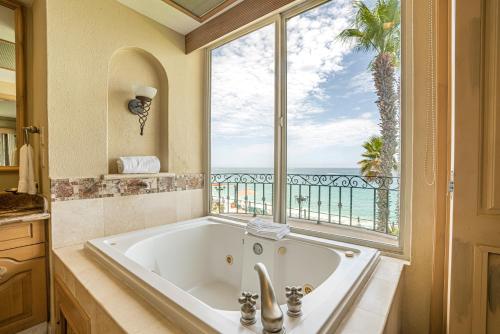 a bath tub in a bathroom with a large window at Villa La Estancia - Medano Beach Villas in Cabo San Lucas