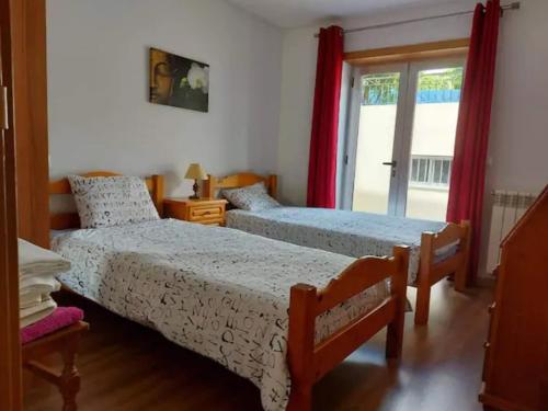 a bedroom with two beds and a window at Casa da Cavada - 6 quartos-rooms in Caminha