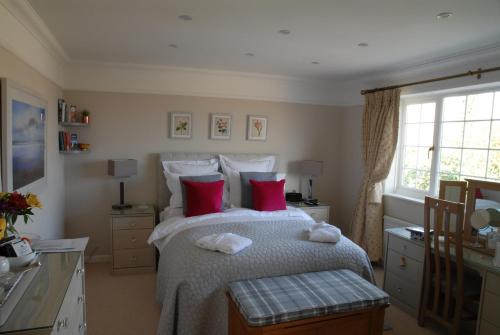 um quarto com uma cama grande e almofadas vermelhas em Hysett House em Midhurst