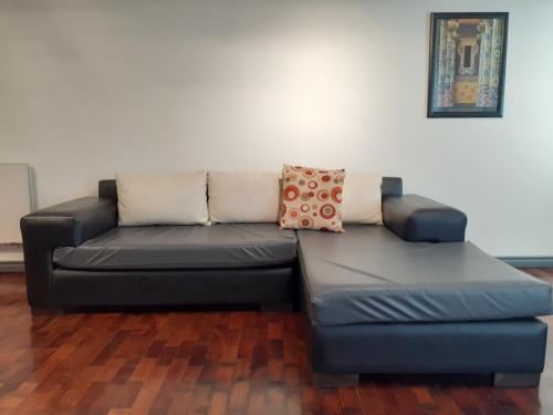Un sofá azul con dos almohadas en una habitación en Departamento España en Mendoza